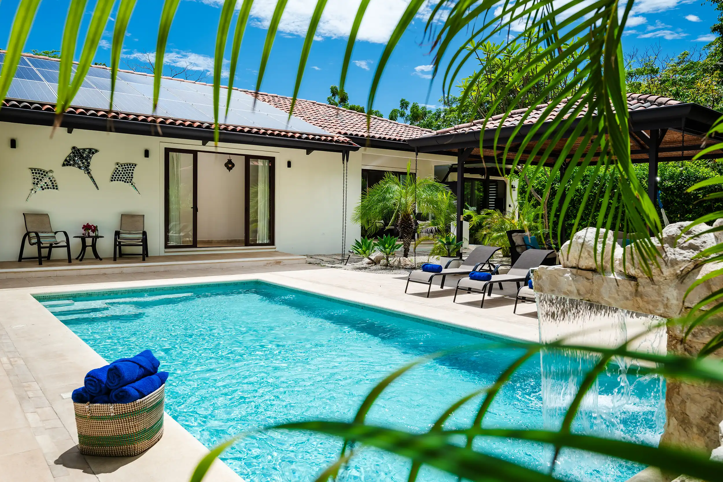 Piscina rodeada de flores tropicales en Casa Bonita Beach
